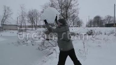 人在冰冻的池塘表面扔一个大雪球.. 慢速视频